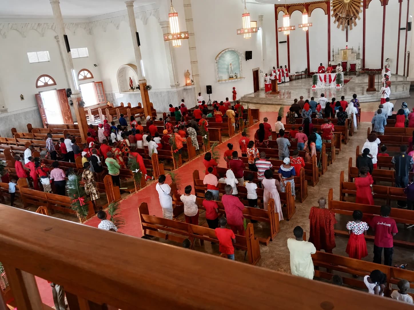 Célébration de la messe, assemblée en tenue liturgique rouge