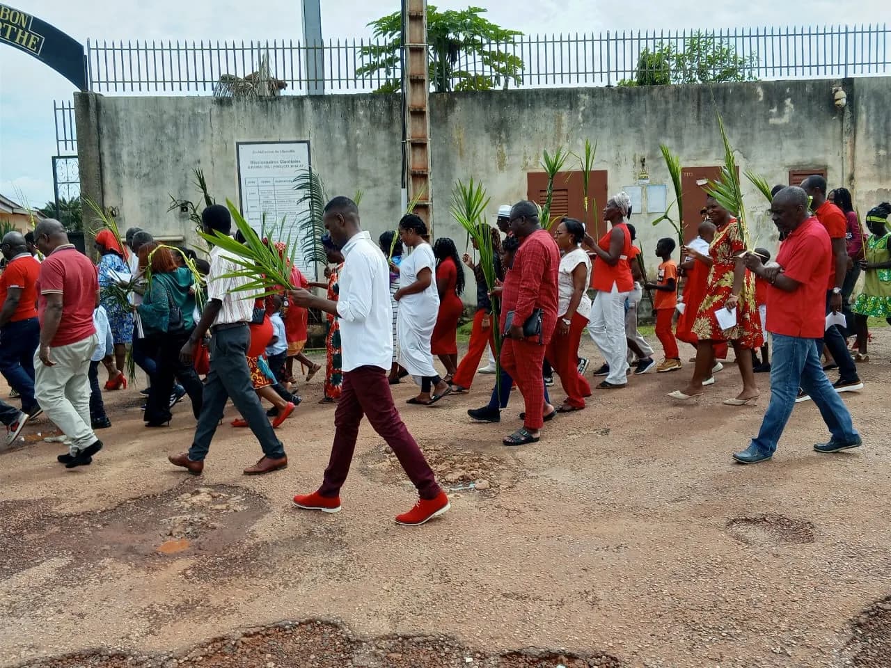 Procession des fidèles en tenue liturgique rouge