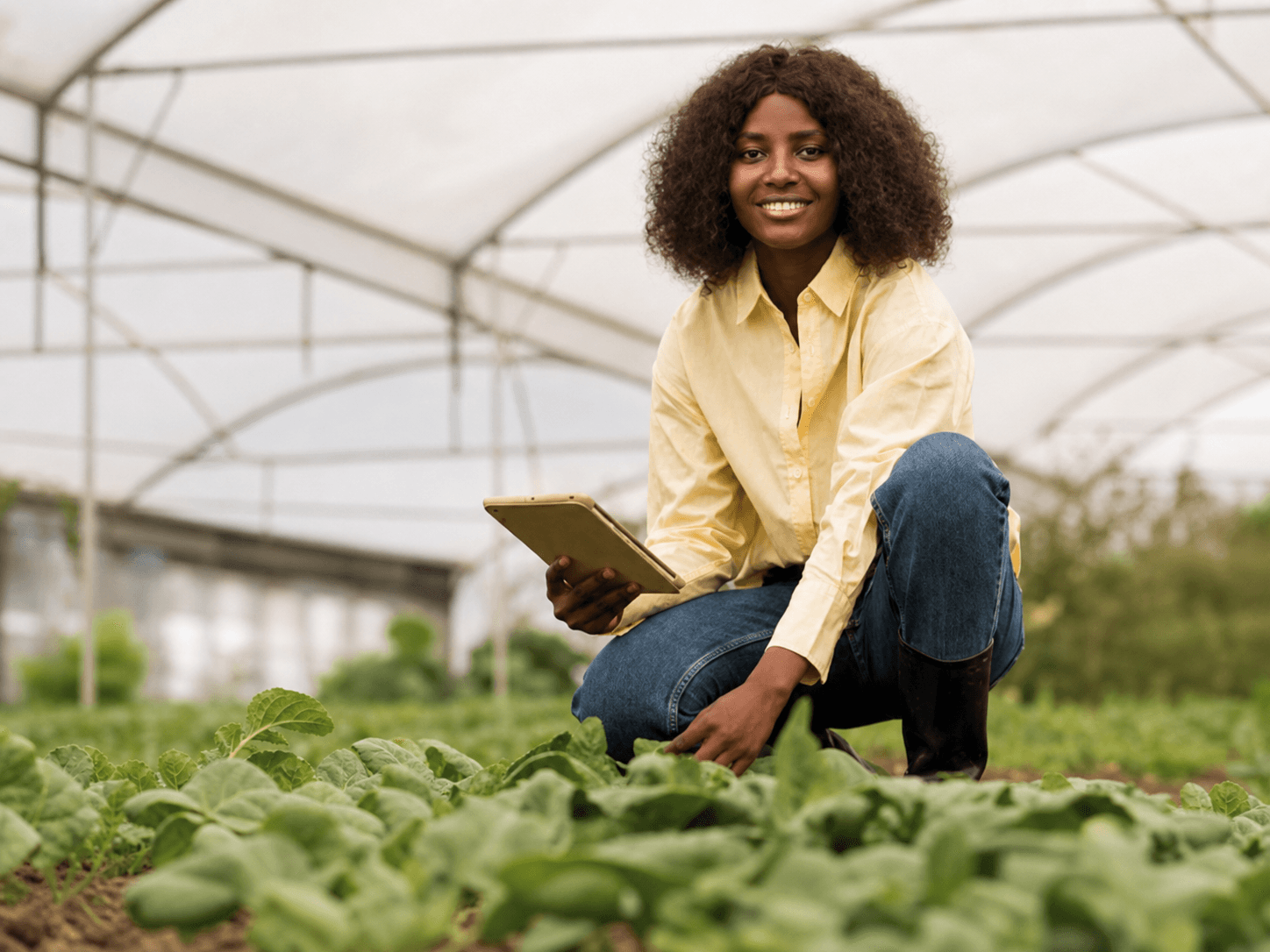 Étudiante observant de jeunes cultures dans une serre agronomique